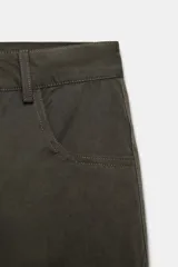 Pantalón cargo de tiro alto con corte holgado y diseño de volumen. Presenta bolsillos laterales tipo cargo, bolsillos frontales clásicos y cierre frontal con cremallera y botón.