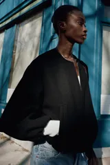 Chaqueta bomber de cuello redondo y manga larga con diseño holgado. Presenta cierre frontal con cremallera, bolsillos delanteros de vivo y acabados elásticos en los puños y el ruedo.