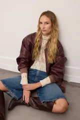 Campera bomber de cuero vacuno en color bordó, con diseño oversized y corte bombé. Presenta cierre frontal, bolsillos laterales y terminaciones de puños, cuello y pretina en tejido de algodón acanalado a tono.