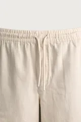 Bermuda de algodón en color beige, con corte relaxed fit, cintura elástica con cordón ajustable y bordado a tono en la pernera.