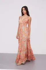 Vestido largo de tirantes finos con escote en V, diseño holgado y falda con volados en el ruedo. Presenta un estampado tipo paisley en tonos naranja y beige.