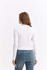 Polera de manga larga con cuello alto, confeccionada en tejido de algodón con textura acanalada y calce ajustado al cuerpo.