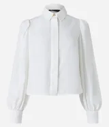 Camisa celeste de crepé con cuello inglés, manga larga abullonada y abotonadura frontal.