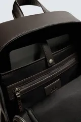 Mochila de diseño minimalista con acabado grabado, compartimento principal con cierre, espacio interior para dispositivos electrónicos de hasta 13 pulgadas, bolsillos frontales con cierre, parte posterior acolchada con banda de sujeción para equipaje, asa de mano y correas de hombro ajustables y acolchadas.