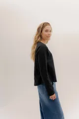 Remera blanca de manga larga con escote a la base. La parte delantera es de algodón y la espalda de remería para mayor elasticidad. Las mangas combinan ambas telas y presenta un detalle de doble entredos en la sisa delantera.