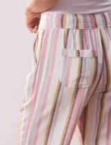 Pantalón capri de lino estampado con rayas verticales en tonos rosa, gris y amarillo. Tiene pretina ancha elastizada, bolsillos inclinados en la parte delantera y cordón ajustable en la cintura.