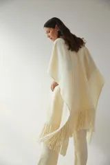 Ruana marrón con flecos y bolsillos. Terminaciones envivadas.