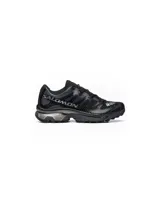 Championes de trail running Salomon modelo XT-4, color negro con detalles en gris y toques de color en la lengüeta. Presentan un diseño técnico con estructura reforzada, sistema de cordones rápidos y suela de alto agarre.