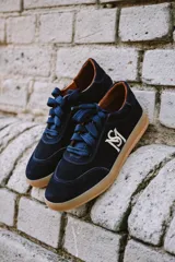 Championes de gamuza azul marino con cordones y suela color caramelo.