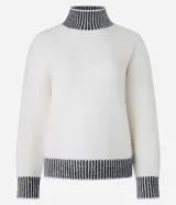 Suéter de punto pesado color blanco con cuello alto, puños y ruedo acanalados en contraste con rayas negras. Presenta diseño de hombros caídos y manga larga.