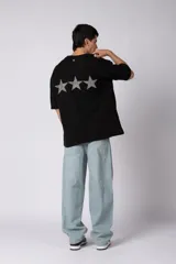 Remeron de corte oversize color negro, con estampa frontal en color gris desgastado que incluye el texto 'CNPT' y tres estrellas. Presenta cuello redondo y mangas cortas amplias.
