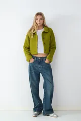 Campera corta de tejido piqué con textura marcada, cuello camisero y cierre frontal de botones. Presenta un calce estructurado y diseño moderno.