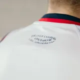 Musculosa de básquetbol Umbro del Club Nacional de Football, color blanco con detalles en azul y rojo en cuello y sisas. Presenta el logo de la marca y el escudo del club en el pecho, junto con la inscripción Nacional en letras grandes.