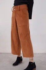 Pantalón marrón de pana con corte cropped y bolsillos frontales.