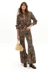 Pantalón de tiro alto confeccionado en corduroy de algodón con estampado floral. Presenta un corte ajustado en la parte superior y un diseño acampanado con volados en el ruedo.