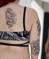 Corpiño negro con estampado de cebra, con breteles finos y tiras cruzadas en el abdomen.