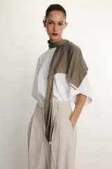 Camiseta blanca de manga corta con corte oversize y cuello redondo. El diseño presenta mangas amplias tipo capa que caen desde el hombro.