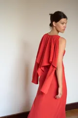 Vestido largo de georgette color rojo, con escote en pico, tirantes finos y detalle de capa fluida integrada en la parte superior.