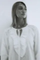 Vestido largo blanco de algodón con mangas largas abullonadas y cuello redondo con detalle de bordado. Presenta aberturas laterales en el ruedo.