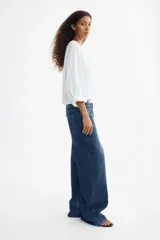 Jean wide leg de tiro alto en denim de algodón con leve elasticidad. Presenta diseño de cinco bolsillos, presillas para cinturón y cierre frontal con botón metálico.