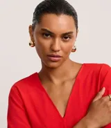 Blusa Cortelle de corte holgado confeccionada en crepé, con escote en V delantero y trasero, y mangas cortas. Presenta una tira decorativa entre los hombros en la espalda.