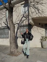 Campera negra de cuero con interior de piel sintética blanca, cierre frontal con cremallera, cuello con solapas y bolsillos laterales.