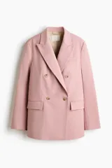 Blazer cruzado rosado con solapas de pico, hombreras y bolsillos delanteros con solapa. Cuenta con cierre de doble botonadura y forro interior.