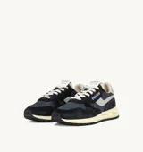Championes Autry modelo Reelwind Low, de estilo retro inspirado en los runners de los 80. Presentan una combinación de ante negro y malla transpirable, con detalles en color crema y suela amortiguada de goma.