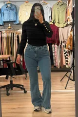 Jean de corte oxford con tiro alto, confeccionado en denim azul con efecto localizado. Presenta cierre frontal con botón y bolsillos laterales y traseros.