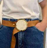 Cinturón de cuero color marrón con faja ancha y hebilla circular grande de bronce con centro de guampa engarzada.