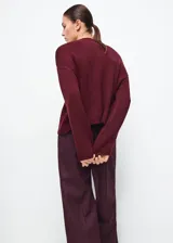Sweater de punto color bordó, con cuello alto, mangas largas y diseño holgado.