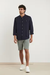 Bermuda de gabardina color verde medio, corte recto y largo a la rodilla.