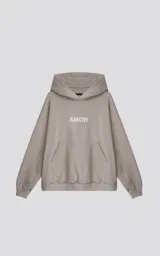 Buzo con capucha color beige claro, de calce oversize crop, con costuras expuestas en mangas y ruedo deshilachado. Presenta la palabra "AMOR" estampada en el pecho en color blanco.