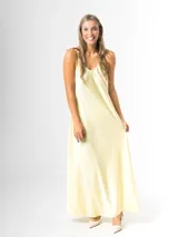 Vestido largo amarillo de satén, de corte recto y holgado, con tirantes finos y escote en V.