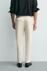 Pantalón regular fit color negro de tejido con viscosa, con cintura elástica ajustable con cordón, bolsillos frontales y traseros.