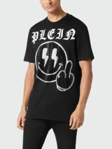 Camiseta negra de manga corta con cuello redondo, confeccionada en algodón. Presenta un estampado frontal con el logo de la marca, un smiley con rayos en los ojos y un dedo medio levantado, decorado con strass.