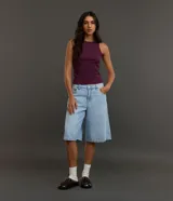 Blusa musculosa básica de color negro, confeccionada en tejido acanalado de algodón con elastano, con cuello redondo y diseño ajustado.