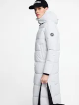 Parka larga acolchada color negro con capucha, cierre frontal con cremallera y bolsillos laterales.