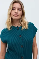 Chaleco tejido de punto acanalado en color rojo, con cuello redondo y cierre frontal de botones oscuros.