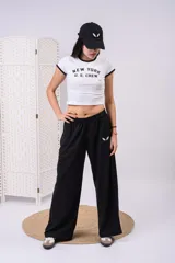 Remera baby tee blanca de corte cropped con ribetes negros en el cuello y las mangas, y estampado frontal con el texto "NEW YORK U.S. CREW".