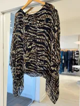 Blusa de seda italiana con estampado animal print que combina leopardo y cebra en tonos negro, marrón y beige, con escote redondo, mangas murciélago amplias y diseño fluido.