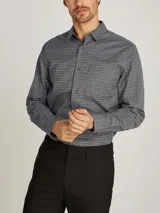 Camisa gris con estampado de cuadros pequeños, de corte regular, cuello en punta, manga larga, bolsillo de parche en el pecho, bajo redondeado y logo bordado en el pecho.