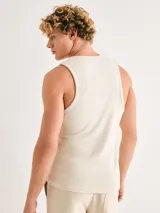 Musculosa blanca de corte slim, confeccionada en tela acanalada (tejido de punto con textura de canalé).