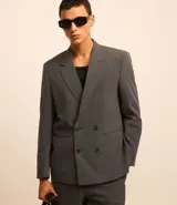 Blazer masculino de sastrería con corte boxy, escote en V, cierre frontal de doble abotonado y bolsillos funcionales. Confeccionado en tejido de poliviscosa con elastano, ofrece una estructura moderna y versátil.
