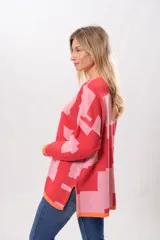 Sweater de punto con diseño geométrico abstracto en tonos rosa y rojo, con cuello redondo y puños y bajo acanalados en color naranja.