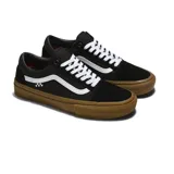 Championes Vans modelo Skate Old Skool, de color negro con la icónica banda lateral blanca y suela de goma color caramelo. Presentan un diseño clásico de perfil bajo con cordones blancos y etiqueta de tablero de ajedrez en el lateral.