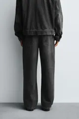 Jeans straight fit de denim de algodón color negro con efecto lavado. Cuentan con cinco bolsillos y cierre frontal de botonadura.