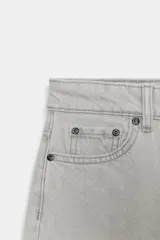 Jeans de tiro medio con corte tapered, confeccionados en denim de color negro con costuras en contraste. Presentan diseño de cinco bolsillos, trabillas en la cintura y cierre frontal con cremallera y botón.