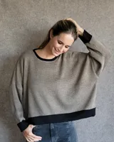 Buzo tostado de corte holgado con cuello redondo y manga larga. Presenta una estrella blanca estampada en la espalda y ribete marrón en cuello y ruedo.