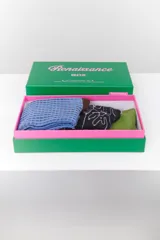 Set de tres pares de medias de caña media con diseños estampados. Incluye un par azul con diseño geométrico, un par negro con diseño floral y un par verde liso.